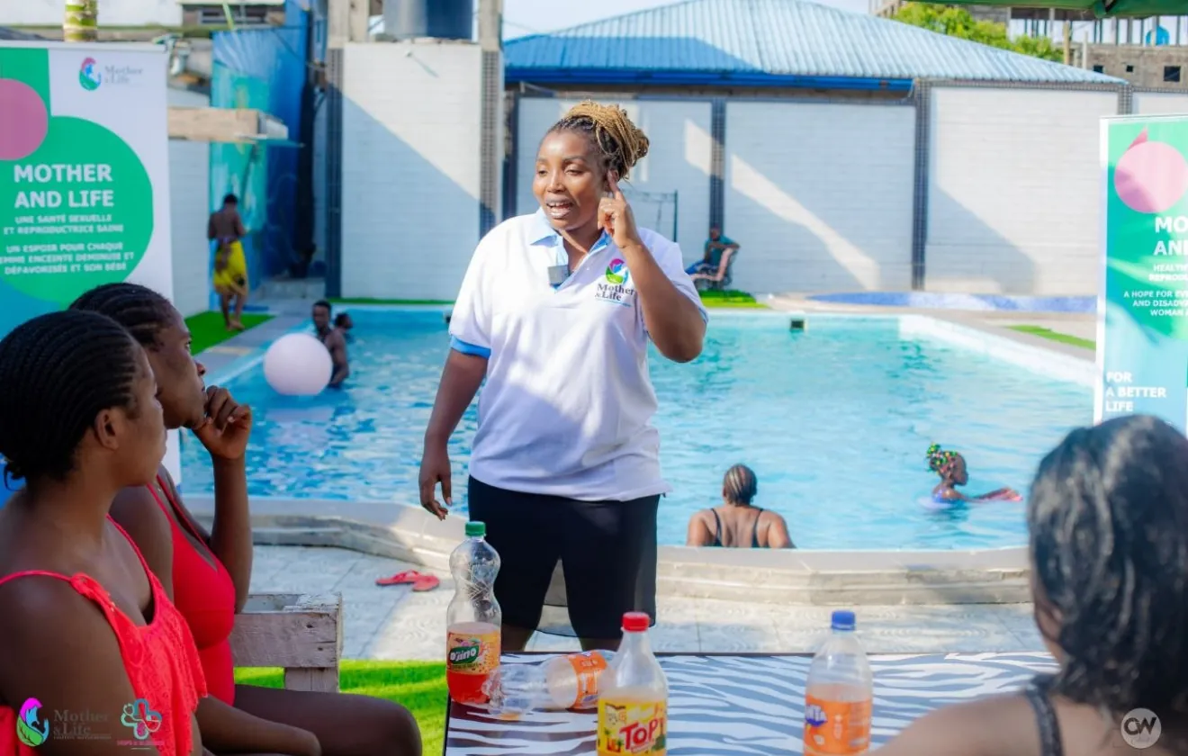 A facilitator speaks to pregnant women by the pool.